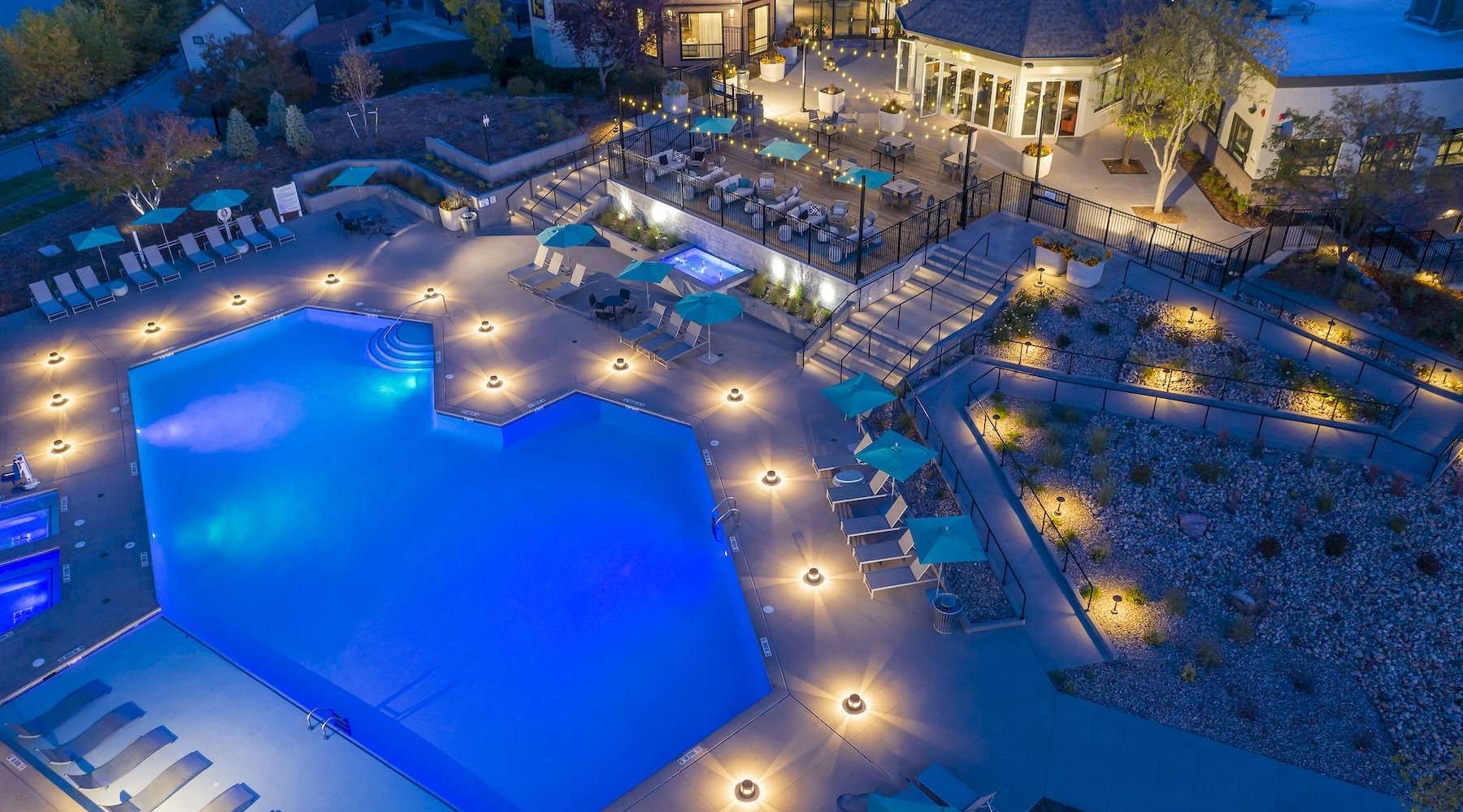 a large swimming pool with lights and chairs
